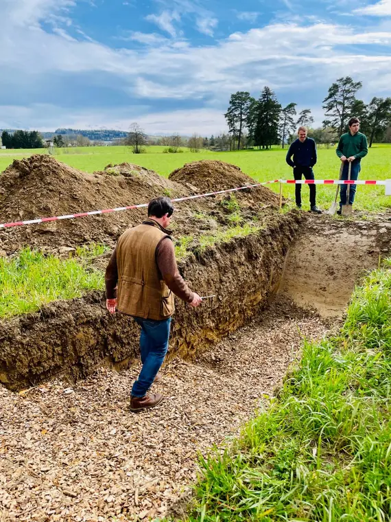 An open trench showing a soil profile in a meadow