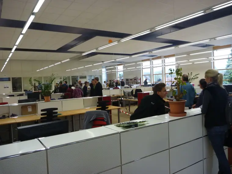 Open-plan electronics engineering office with visitors