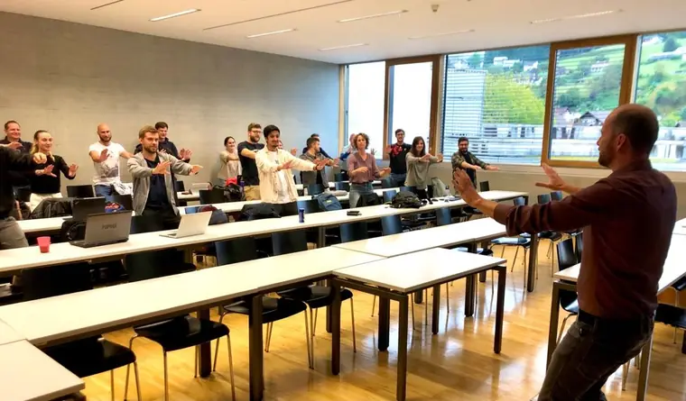 Talk at FH Vorarlberg, students standing and joining an exercise