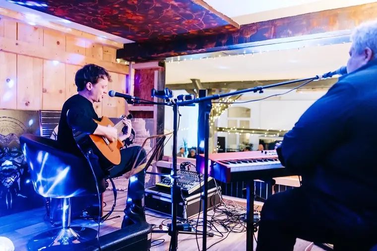 Musicians with guitar and keyboard on a small stage