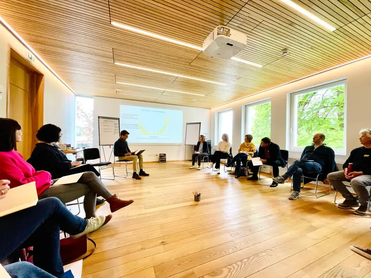 Theory U workshop in a circle of chairs in a timber room
